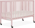 Quinn Full-Size Folding Crib in Blush Pink, Removeable Wheels, Modern Nursey, Adjustable Mattress Support, Portable Crib, Patented Folding System